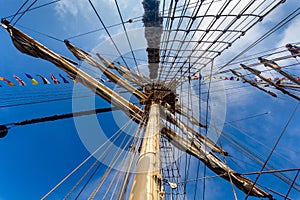 Cable ladders, mast and ropes of a sailing ship against the blue sky. Concept of travel, adventure and sea.