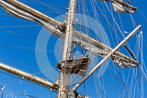 Cable ladders, mast and ropes of a sailing ship against the blue sky. Concept of travel, adventure and sea.