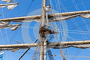 Cable ladders, mast and ropes of a sailing ship against the blue sky. Concept of travel, adventure and sea.