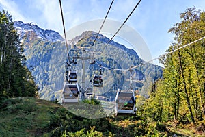 Cable lift in Gorky Gorod in Sochi mountain ski resort on Caucasus mountain peaks background on sunny summer day. Scenic landscape