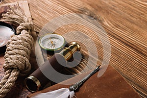 Cable, nib, compass and telescope on wooden surface