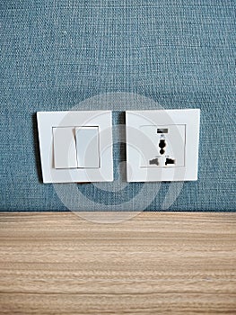 Cable plugs and room light switches blend in with the solid color of the wallpaper