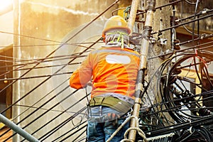 Cable repair technician are to fix the lines of network cable and wires on electric pole with sun flare