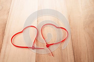 Cable ties heart shape on wood background , holiday abstract background