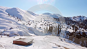 Cable way car in Goderdzi ski resort with old wooden houses in Adjara mountains in winter