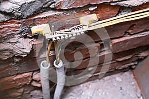 Cables connected to a copper ground bus bar on a brick wall, protection against electricity leak