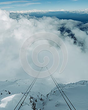 Cables of funicular go into clouds.