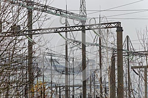 Cables and modular suspension insulators for overhead power line. Transmission tower. Metal construction. The sky in the fog, gray