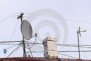 Cables, telecommunication wire and satellite tv antenna on the rooftop