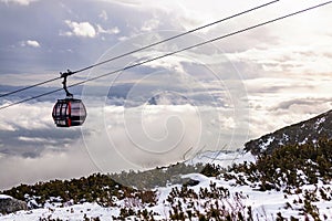 Cableway cabin above the clouds at sunset