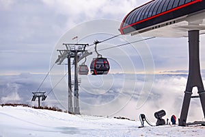 Cableway cabin above the clouds at sunset