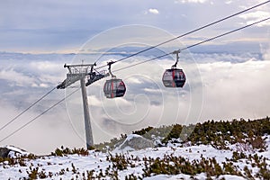 Kabina lanovky nad mraky při západu slunce