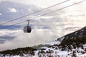 Cableway cabin above the clouds at sunset