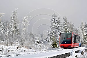 Cableway cabin on rails in mountains in fog