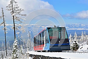 Cableway cabin on rails in mountains in a sunny day