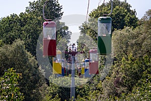 Cableway with cable car cabins in the park in a sunny summer day