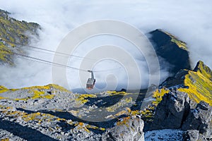 Cableway in the mountains. Transportation. The cable car descends into the mountain valley. photo