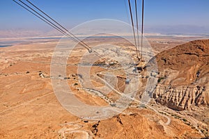 Cableway from rock top of  Fortress Masada 1st century. Cable car over Judaean Desert. Dead Sea coast. Herod the Great palace