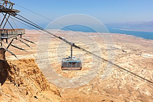 Cableway from rock top of  Fortress Masada 1st century. Cable car over Judaean Desert. Dead Sea coast. Herod the Great palace