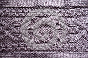 Cabling pattern on puce knitted fabric