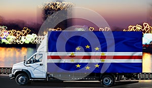 Cabo Verde flag on the side of a white van against the backdrop of a blurred city and river. Logistics concept