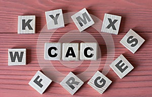 CAC - acronym on wooden cubes on a pink wooden background