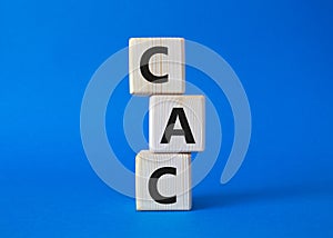 CAC - Customer Acquisition Cost symbol. Wooden cubes with word CAC. Beautiful blue background. Business and Customer Acquisition