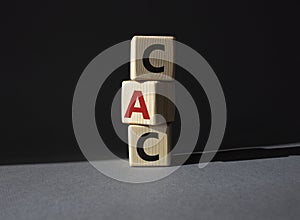 CAC - Customer Acquisition Cost symbol. Wooden cubes with word CAC. Beautiful grey background. Business and Customer Acquisition