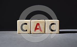 CAC - Customer Acquisition Cost symbol. Wooden cubes with word CAC. Beautiful grey background. Business and Customer Acquisition