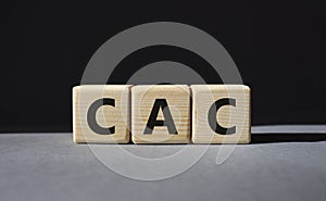 CAC - Customer Acquisition Cost symbol. Wooden cubes with word CAC. Beautiful grey background. Business and Customer Acquisition