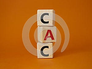 CAC - Customer Acquisition Cost symbol. Wooden cubes with word CAC. Beautiful orange background. Business and Customer Acquisition