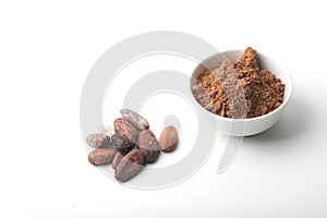 Cacao beans and a bowl of cacao powder isolated on white background. Plan view