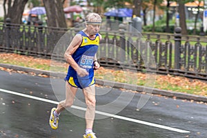 Cacasian senior running on a city street during 21 km distance of ATB Dnipro Marathon