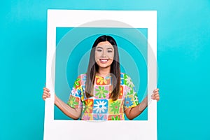 Cadre of young lady wear stylish tropical colorful t-shirt hold paper borders memories photozone isolated on aquamarine