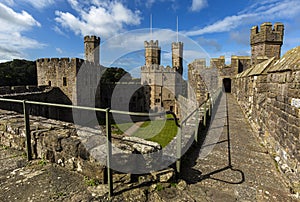 Caernarfon castle. And battlements along the River Seiont in North Wales, United Kingdom photo