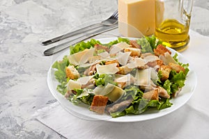 Caesar salad with chicken and herbs on the table, Caesar sauce, Parmesan cheese