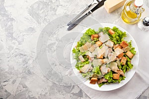 Caesar salad with chicken and herbs on the table, Caesar sauce, Parmesan cheese