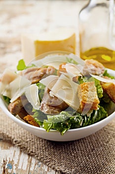 Caesar salad with chicken and herbs on the table, Caesar sauce, Parmesan cheese