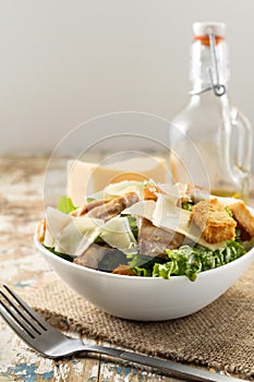 Caesar salad with chicken and herbs on the table, Caesar sauce, Parmesan cheese