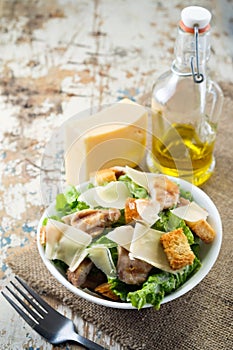 Caesar salad with chicken and herbs on the table, Caesar sauce, Parmesan cheese