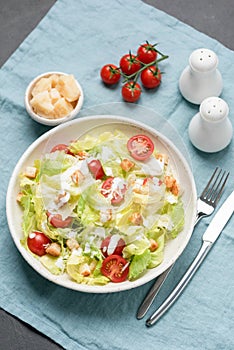 Caesar salad with chicken and sauce on white plate