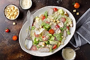 Caesar salad with chicken, tomatoes, Parmesan and croutons