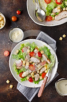 Caesar salad with chicken, tomatoes, Parmesan and croutons