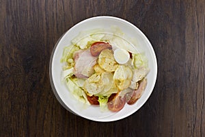 Caesar salad delicious healthy food tomatoes croutons Parmesan cheese and fresh mozzarella on wood background