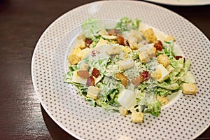 Caesar salad is a green salad of romaine lettuce, Bacon Fried and croutons in white plate