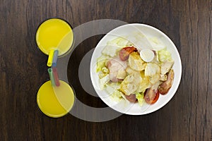 Caesar salad orange juice delicious healthy food tomatoes croutons Parmesan cheese and fresh mozzarella on wood background