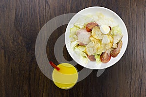 Caesar salad orange juice delicious healthy food tomatoes croutons Parmesan cheese and fresh mozzarella on wood background