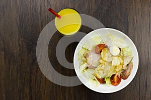 Caesar salad orange juice delicious healthy food tomatoes croutons Parmesan cheese and fresh mozzarella on wood background