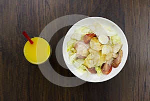 Caesar salad orange juice delicious healthy food tomatoes croutons Parmesan cheese and fresh mozzarella on wood background