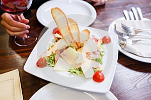 Caesar salad served on white plate in restaurant